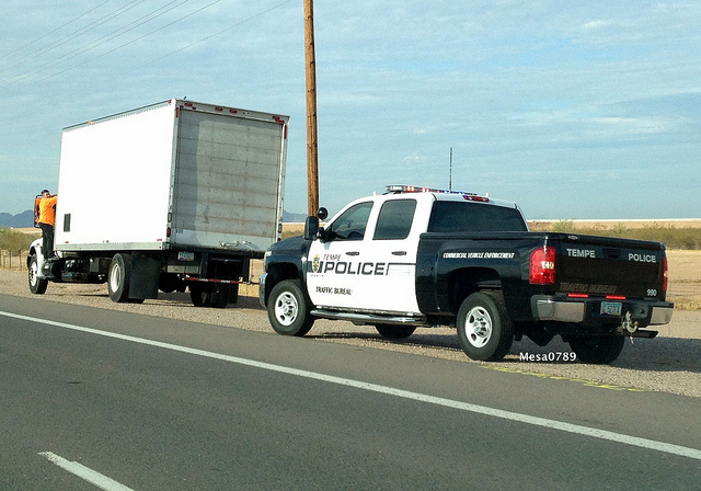 DUI charges in Arizona - police vehicle stopped behind a truck
