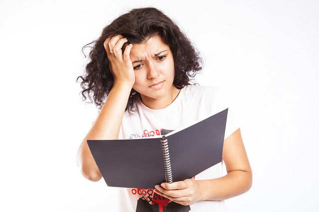 Decoding “Legalise”: Common Legal Phrases Defined - confused person looks into a spiral-bound book