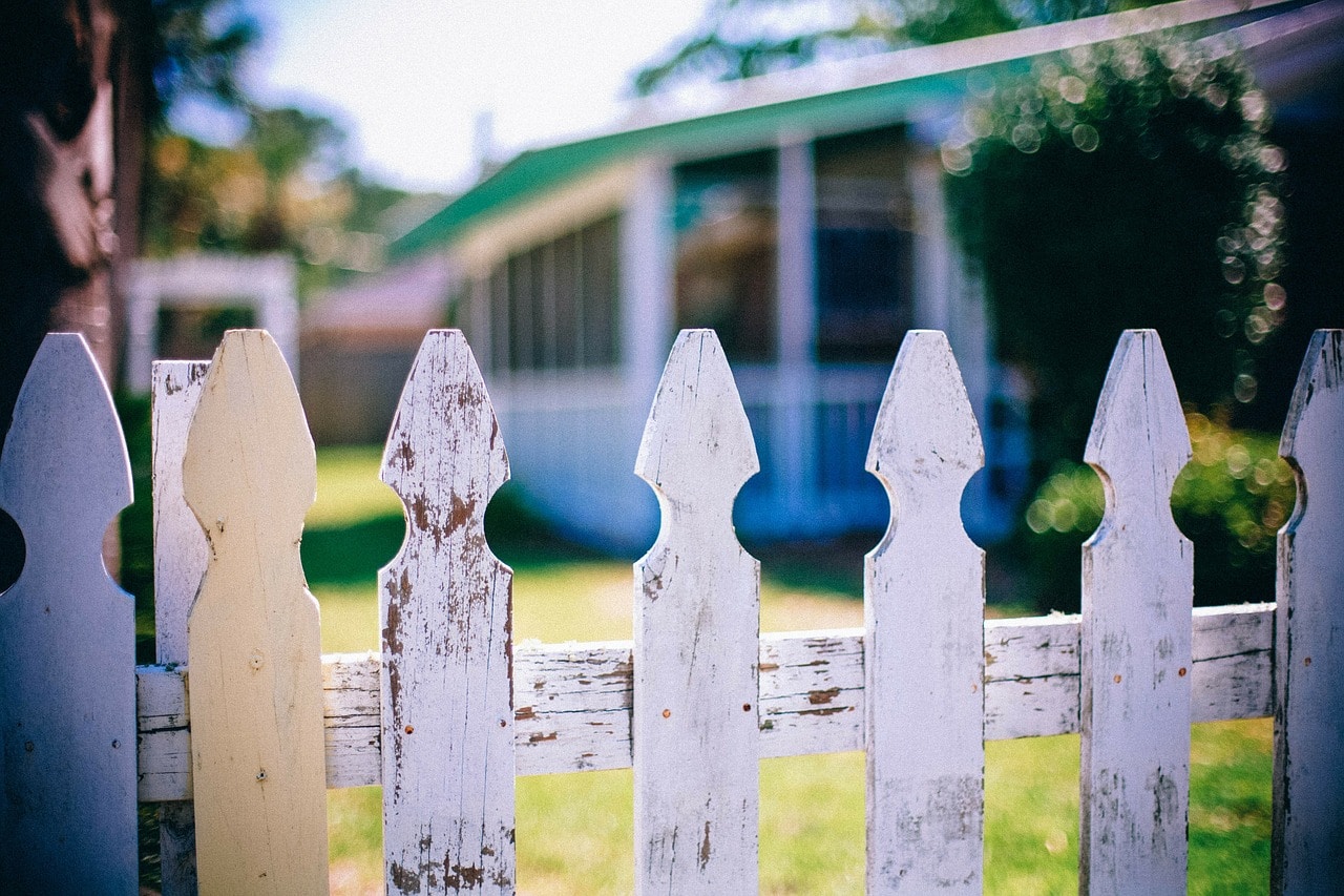 project safe neighborhoods -- white picket fence with a house and yard in the background