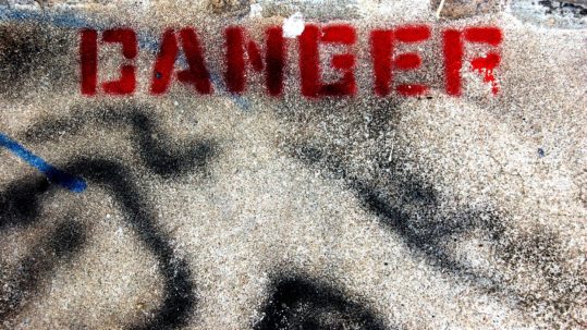 dangerous offense crime - word danger spray painted in red on concrete