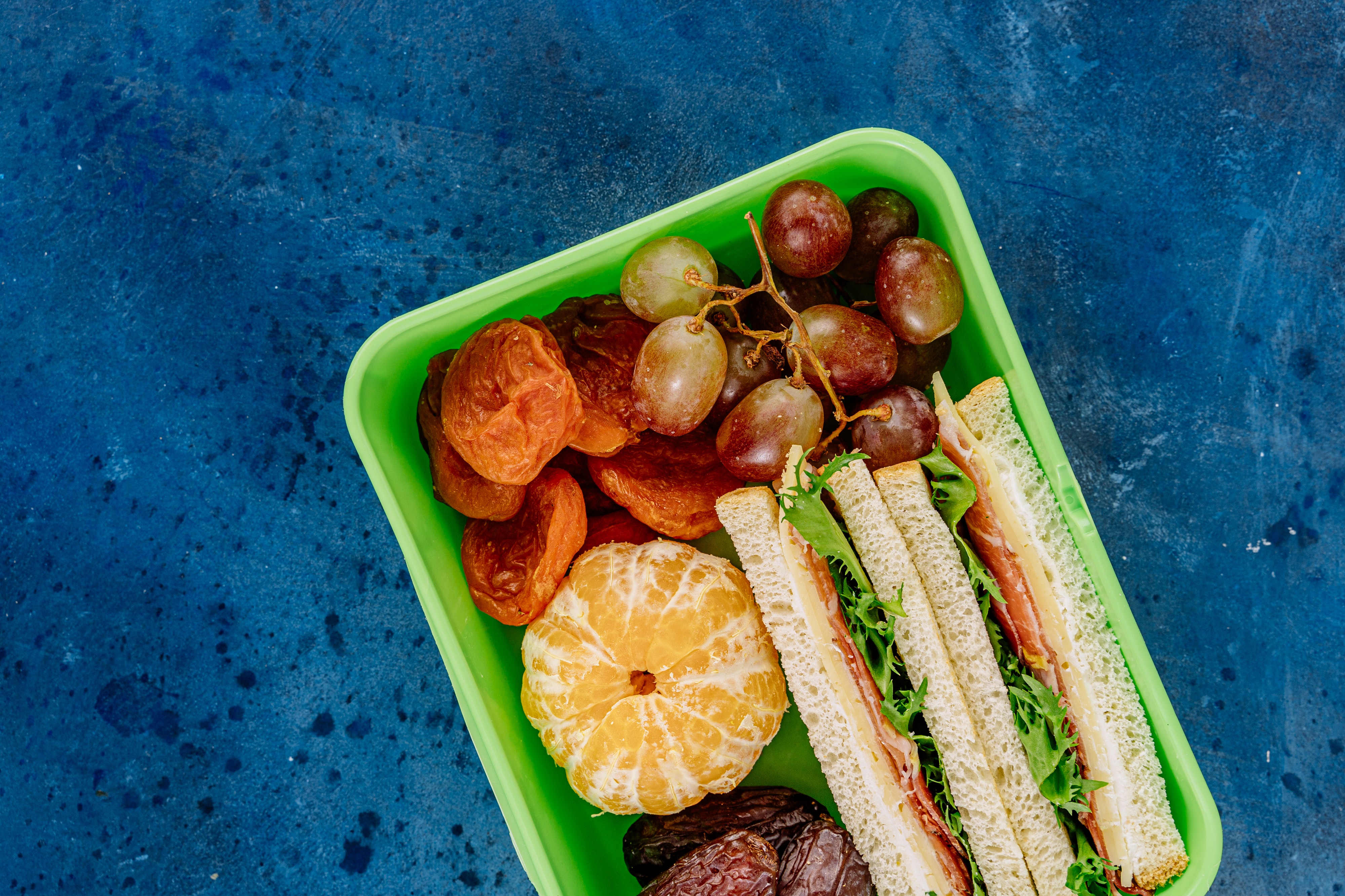 green lunch box with sandwich and fruit - illegal to put laxatives in someone's food