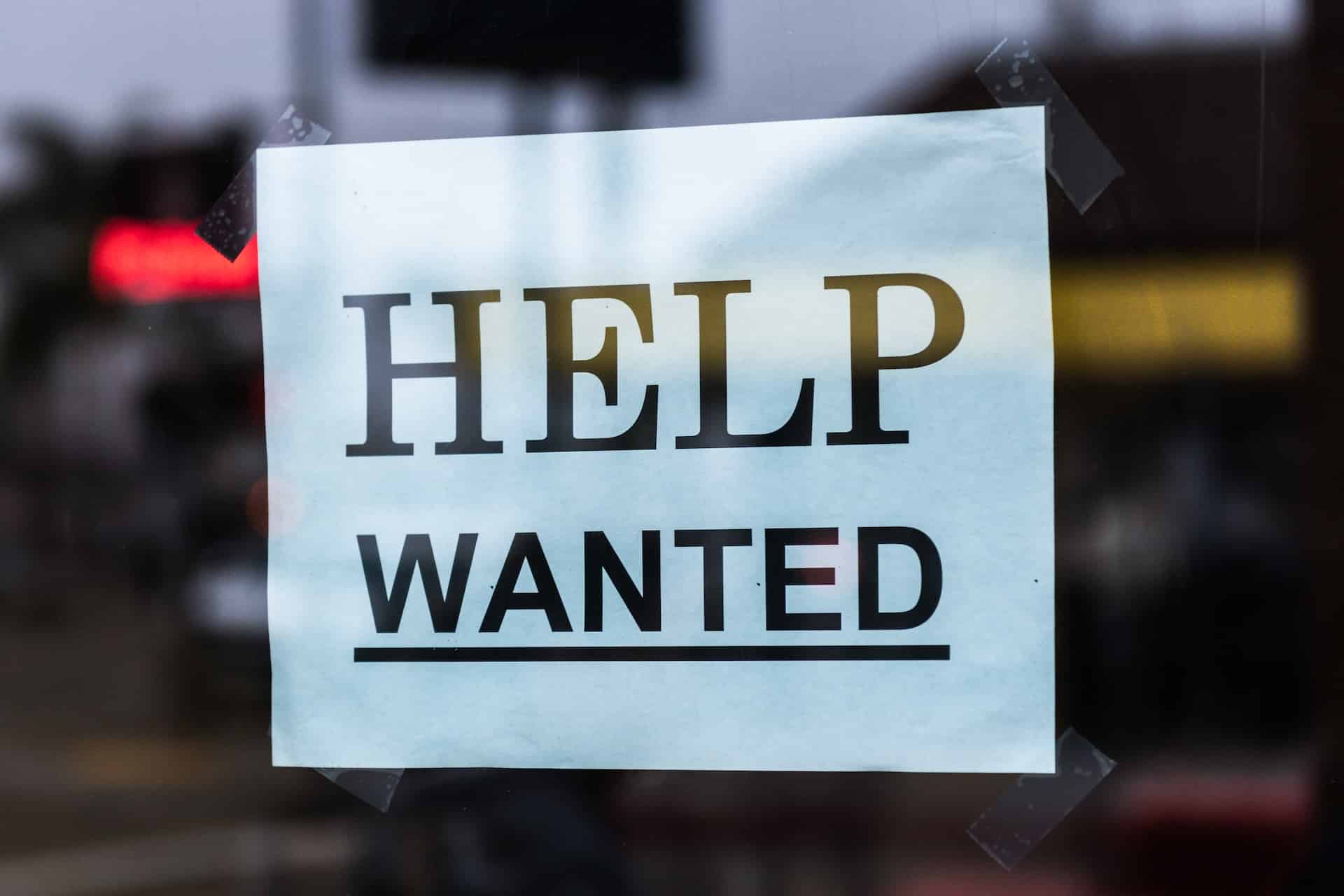 help wanted sign in a shop window - difficult for felon to get a job