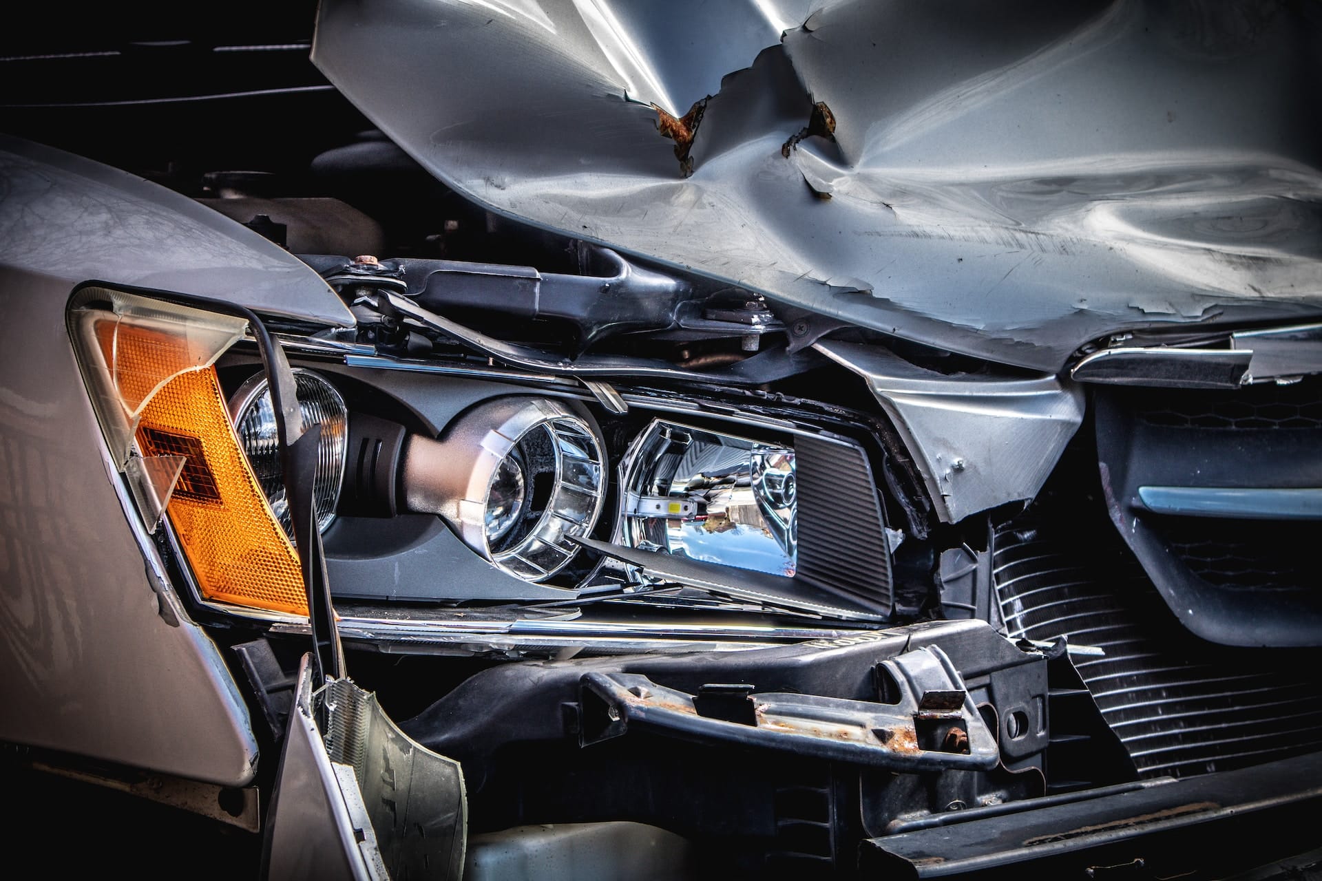 silver car with a damaged hood and bumper - distracted driving