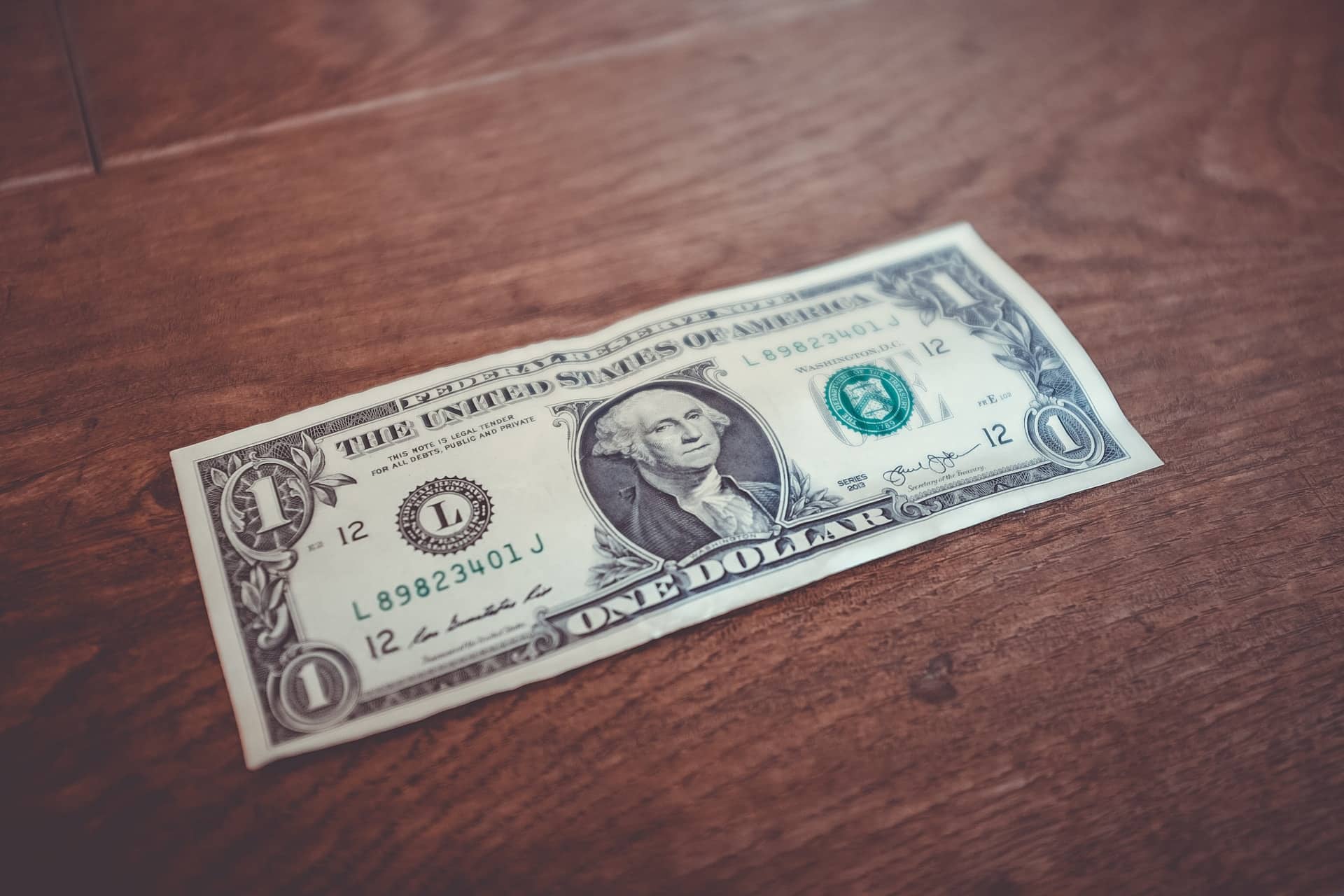 a dollar bill on a brown table - Arizona court fees