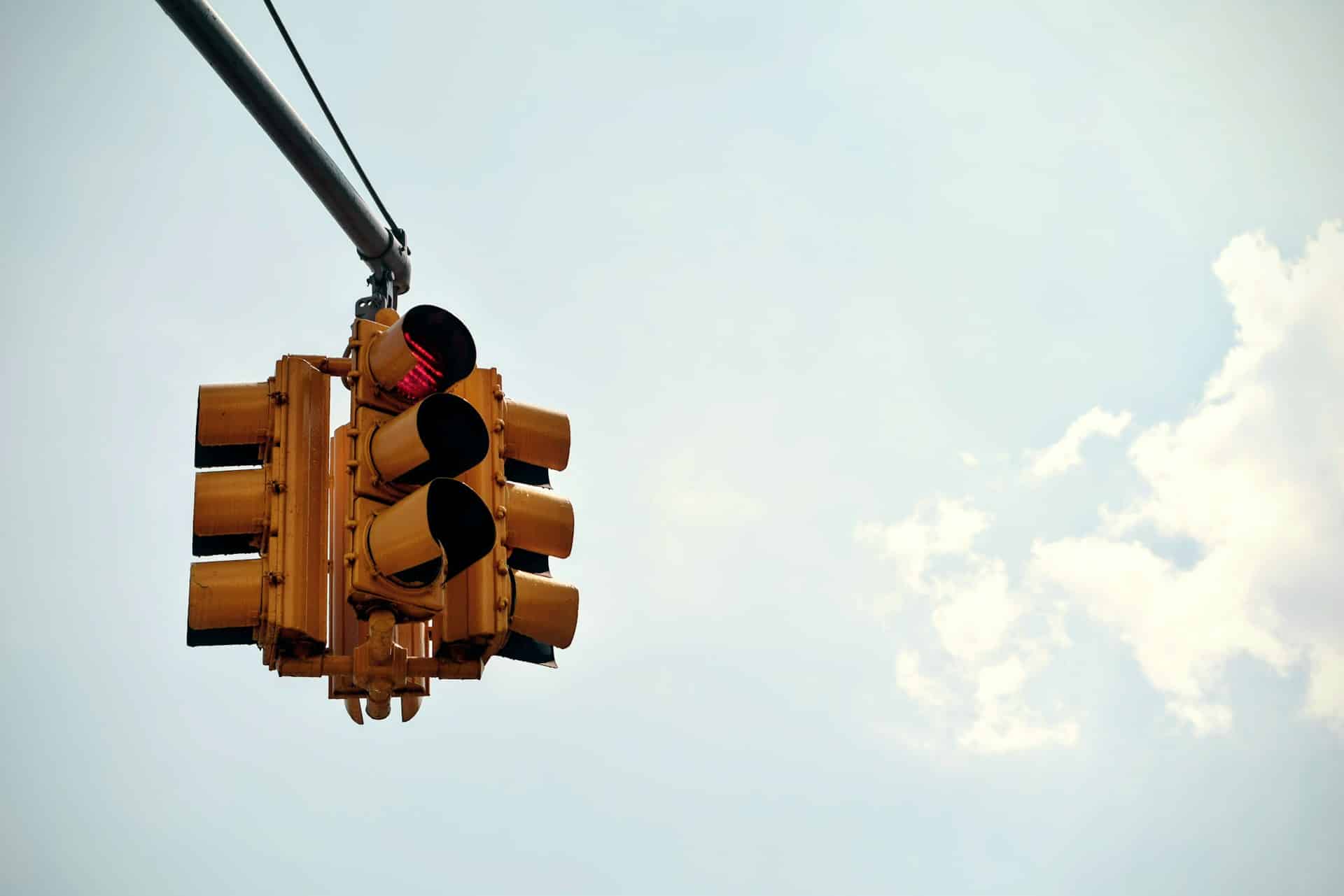 blue sky, with yellow traffic light and red light